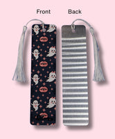 Front and Back side of a bookmark, one side showing a ghost and vampire lips design and the other side showing the aluminum look, on a pink background.