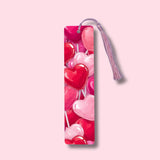 Bookmark with heart-shaped lollipops on a pink background