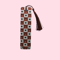Decorative bookmark with heart and bow pattern and tassel on a pink background