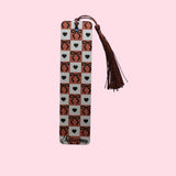 Decorative bookmark with heart and bow pattern and tassel on a pink background