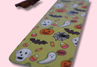 Halloween-themed bookmark with ghosts, pumpkins, and bats on a pink background