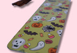 Halloween-themed bookmark with ghosts, pumpkins, and bats on a pink background