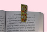 Colorful bookmark with Halloween designs on an open book against a pink background