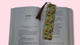 Open book with a decorative bookmark featuring Halloween-themed illustrations on a pink background