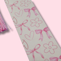 Decorative bookmark with pink bows, hearts, and flowers on a light pink background.