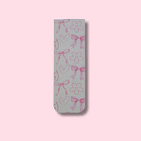Bookmark with pink bows, hearts, and flowers on a pink background