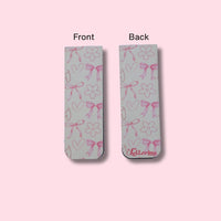 Two bookmarks showing the front and back side of the bookmark with bows, hearts, and flowers pattern on a pink background