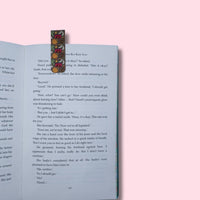 Open book with a mangetic bookmark on a pink background