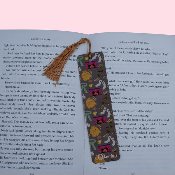 Decorative bookmark with tassel on an open book against a pink background