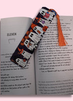 Bookmark with ghosts design on an open book against a pink background