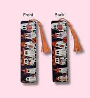 Bookmark with tassels, one showing front and the other back, on a pink background.