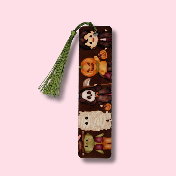 Decorative bookmark featuring halloween-themed designs with tassel on a pink background