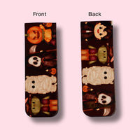 Two views of a magnetic bookmark with Halloween-themed design on a pink background