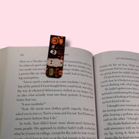 Open book with a colorful bookmark on a pink background