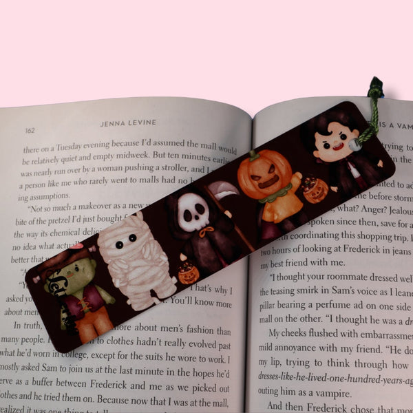 Halloween-themed bookmark on an open book with a pink background