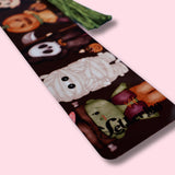 Decorative aluminum bookmark with Halloween-themed designs on a pink background