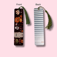 Two view of a bookmark, one with a cartoon character dressed in halloween costumes design and the other with an aluminum look, on a pink background.