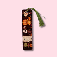 Decorative aluminum bookmark with cartoon characters dressed in halloween costumes design on a pink background