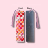 Heart-patterned bookmark with tassel on a pink background