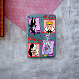 A clear phone case featuring a colorful graphic collage of evil queens, placed on a textured gray surface with a pink patterned paper background.