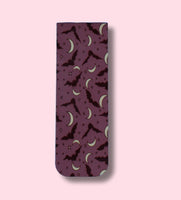 a bookmark with bats and crescent moons patterns on a pink background