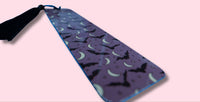 Purple bookmark with bat and moon pattern on a pink background