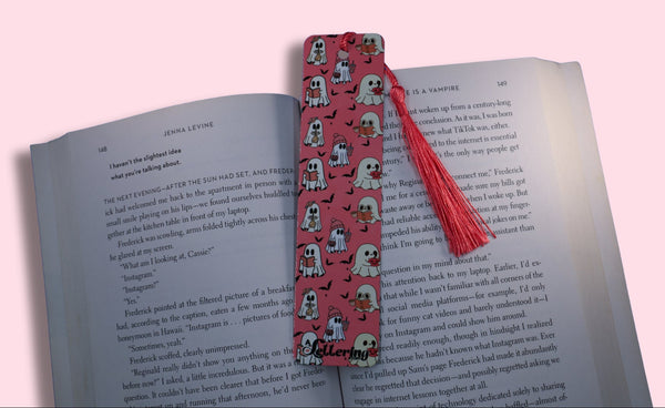 Book with a pink bookmark featuring ghost patterns on a pink background