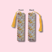Front and back side of bookmark with fall pattern and yellow tassels on a pink background