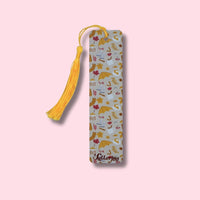 Autumn-patterned aluminum bookmark with yellow tassel on a pink background