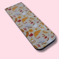 Magnetic bookmark with autumn-themed design on a pink background