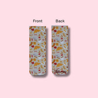 Two views of a magnetic bookmark with a colorful autumn design on a pink background