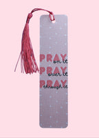 Pink Bookmark with quote "Pray on it, Pray over it, Pray Through it" with a tassel on a pink background