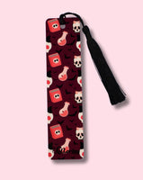 Patterned bookmark with a black tassel on a pink background