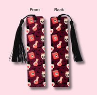 Two bookmarks with tassels, one showing front and the other back design on a pink background.