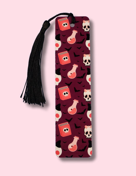 Bookmark with potion bottles, spell books and skull pattern on a pink background