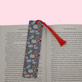 Decorative bookmark with winter gear on an open book against a pink background