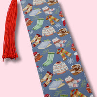 Blue bookmark with winter-themed illustrations on a pink background