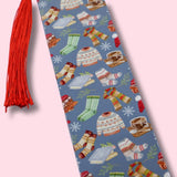 Blue bookmark with winter-themed illustrations on a pink background
