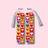 Colorful heart-patterned bookmark with tassel on a pink background