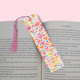 Colorful heart-patterned bookmark with a pink tassel on an open book